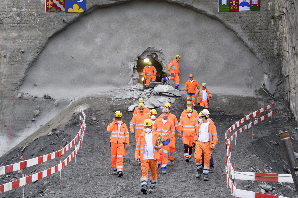 Des ouvriers sortent du tunnel fraîchement percé. 