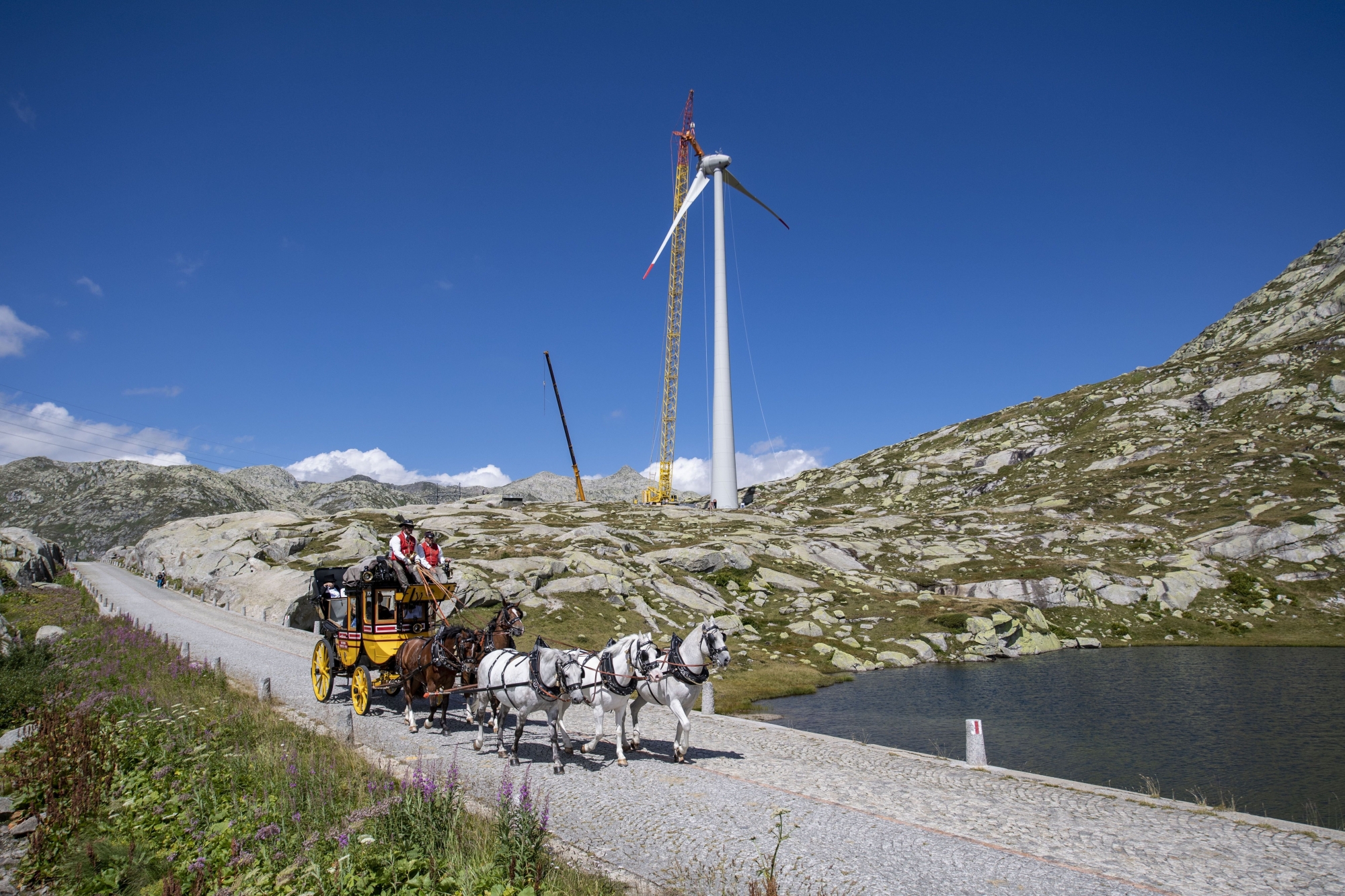 Die Gotthard Postkutsche faehrt am Donnerstag, 20. August 2020 an einem, im Bau befindenden Windrad vorbei. Auf dem Gotthard Pass werden zur Zeit die Windraeder des Windparks der Azienda Elettrica Ticinese, AET, aufgebaut. (KEYSTONE/Urs Flueeler) ArcInfo