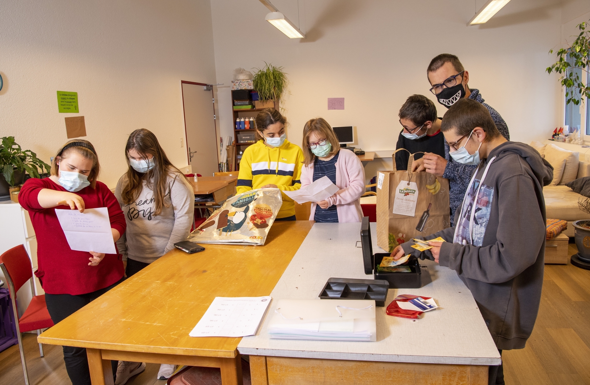 Dans leur classe, les élèves de la CSSP examinent les listes reçues avant d'aller faire les courses en ville.