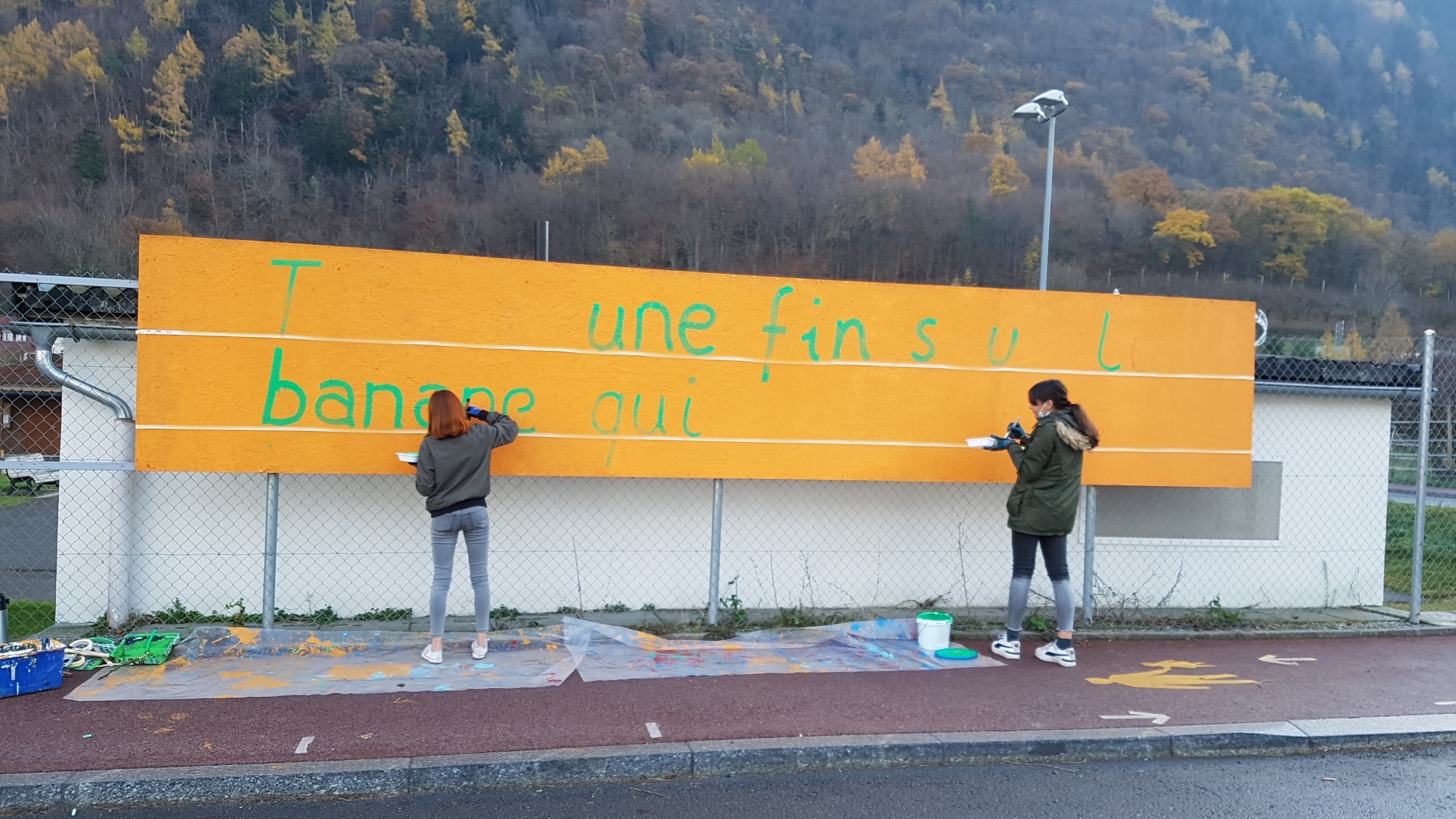 Tania et Mira, deux membres de la Brigade du bonheur, peignent un panneau situé au Guercet.