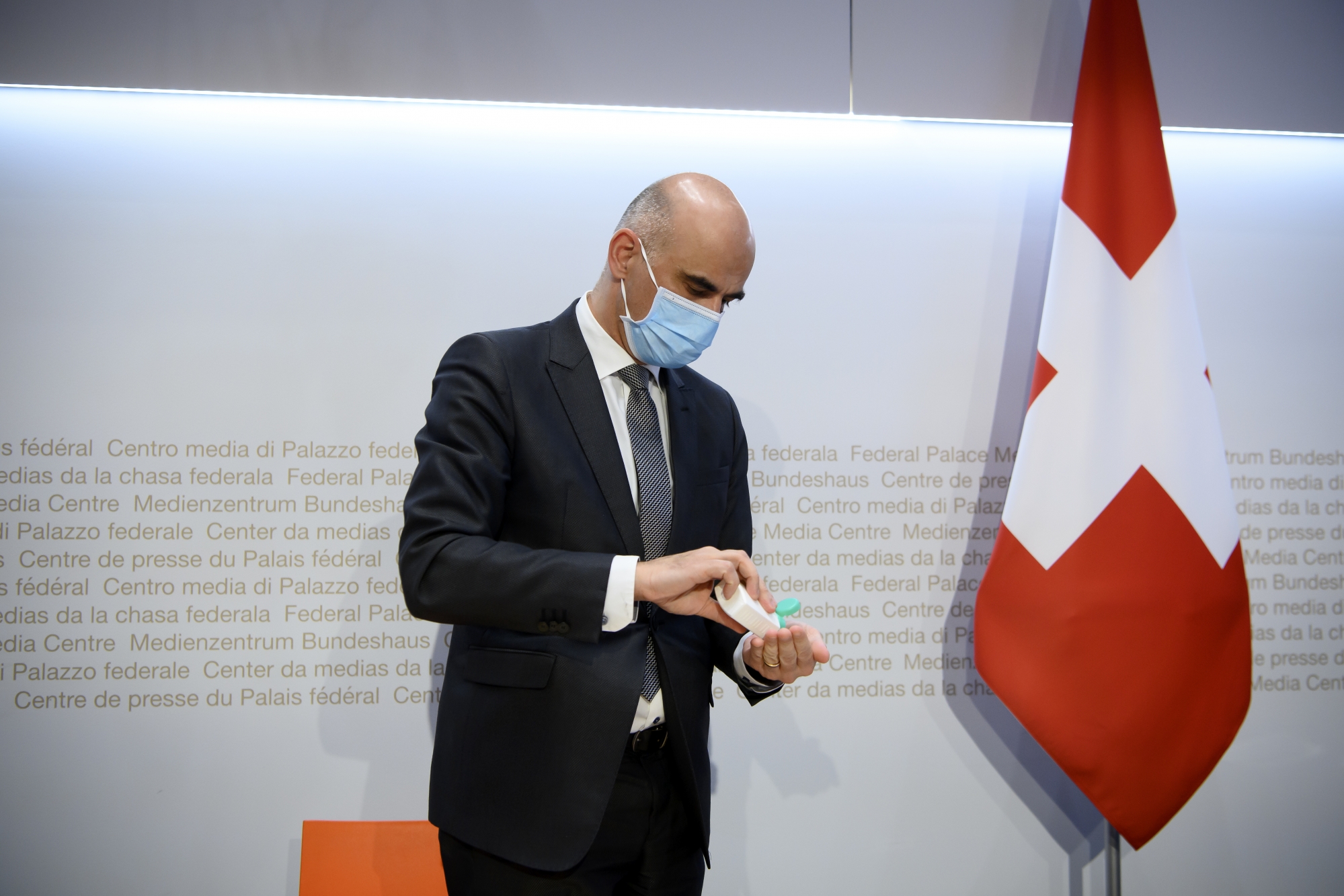 Bundesrat Alain Berset desinfiziert seinem Haende nach einer Medienkonferenz zum aktuellen Stand der Coronapandemie, am Mittwoch, 3. Februar 2021, im Medienzentrum Bundeshaus in Bern. (KEYSTONE/Anthony Anex)