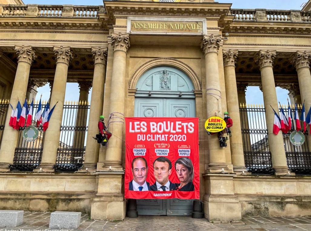 Deux grimpeurs ont escaladé des colonnes du porche d'entrée de l'Assemblée nationale pour déployer une banderole à l'effigie des gagnants.