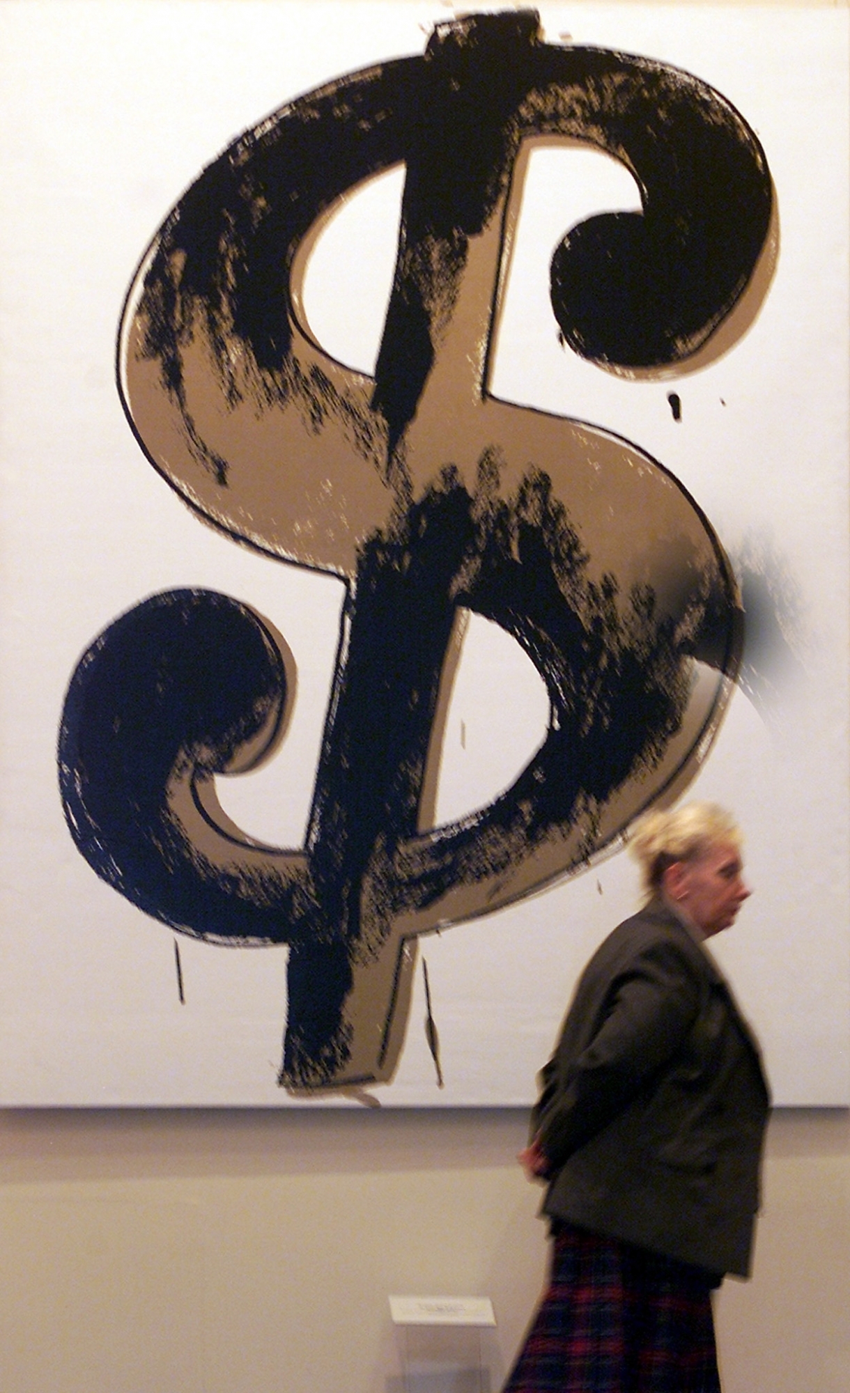 A museum staffer passes by Andy Warhol's " Dollar Sign" created in 1981, during a Warhol exhibition in Moscow's Pushkin Arts Museum, 28 May 2001, during Warhol's week , which is being held in Moscow from 28 May till 03 June. EPA PHOTO/ Alexander NEMENOV