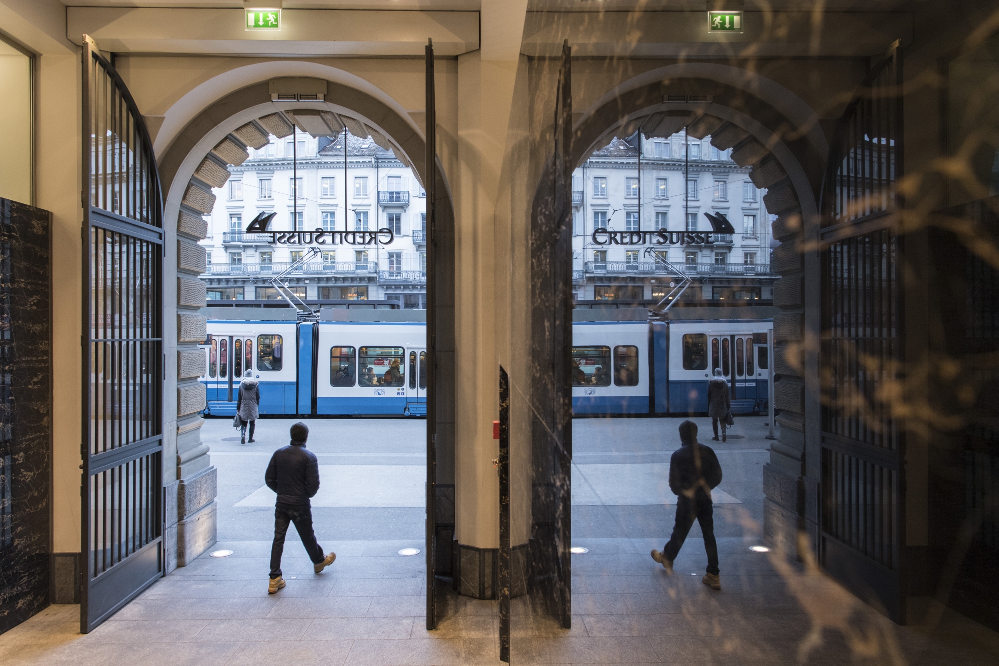 People walk in the front of the Credit Suisse bank at the tram stop Paradeplatz in the square's centre in Zurich, Switzerland, Wednesday, Feburary 14, 2018. (KEYSTONE/Ennio Leanza).