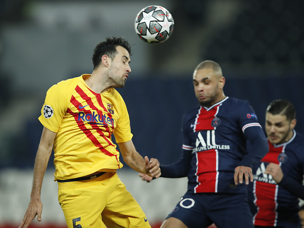 Le Barcelonais Sergio Busquets prend le ballon de la tête devantle Parisien Layvin Kurzawa.