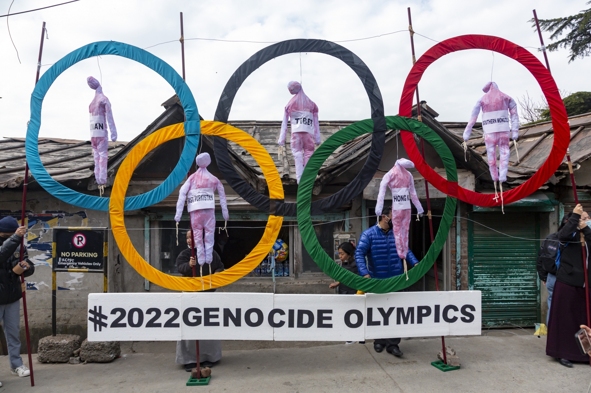 FILE - In this Feb. 3, 2021, file photo, exile Tibetans use the Olympic Rings as a prop as they hold a street protest against the holding of 2022 Winter Olympics in Beijing in Dharmsala, India. The U.S. State Department spokesman on Tuesday, April 6, 2021, suggested that an Olympic boycott to protest China&#x201a;Äôs rights abuses was among the possibilities. But a senior official said later that a boycott has not yet been discussed. (AP Photo/Ashwini Bhatia, File)