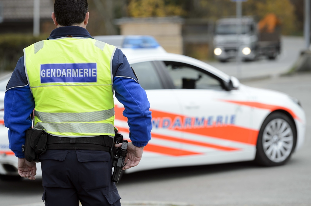 [Editor's note: photo mise-en-scene] A police officer of the cantonal police of Vaud, in the foreground, and a police car, in the background, photographed in Cugy, in the Canton of Vaud, Switzerland, on November 3, 2015. (KEYSTONE/Laurent Gillieron)  [Editor's note: photo mise-en-scene] Un policier (gendarme) du corps de gendarmerie de la Police cantonale vaudoise photographies proche d'une voiture de police ce mardi 3 novembre 2015 a Cugy, Vaud. (KEYSTONE/Laurent Gillieron)