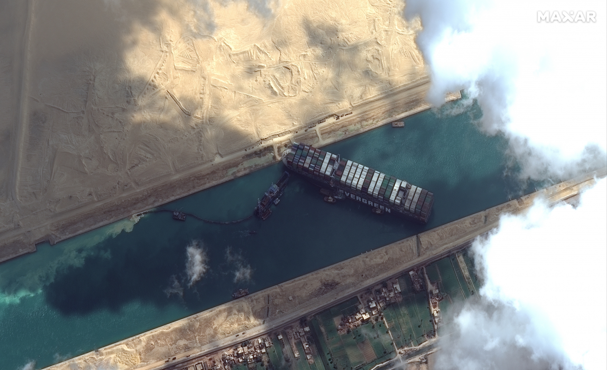 This satellite image from Maxar Technologies shows the cargo ship MV Ever Given stuck in the Suez Canal near Suez, Egypt, Friday, March 26, 2021. A maritime traffic jam grew to more than 200 vessels Friday outside the Suez Canal and some vessels began changing course as dredgers worked frantically to free a giant container ship that is stuck sideways in the waterway and disrupting global shipping. (©Maxar Technologies via AP)