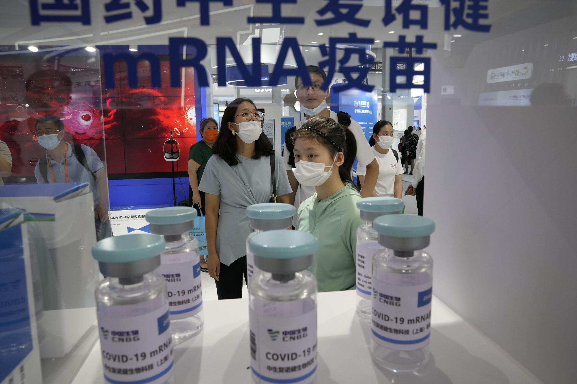 Visitors look at giant replica bottles of COVID-19 vaccine produced by Sinopharm subsidiary CNBG using mRNA technologies at the China International Fair for Trade in Services (CIFTIS) in Beijing, China on Sunday, Sept. 5, 2021. (AP Photo/Ng Han Guan)