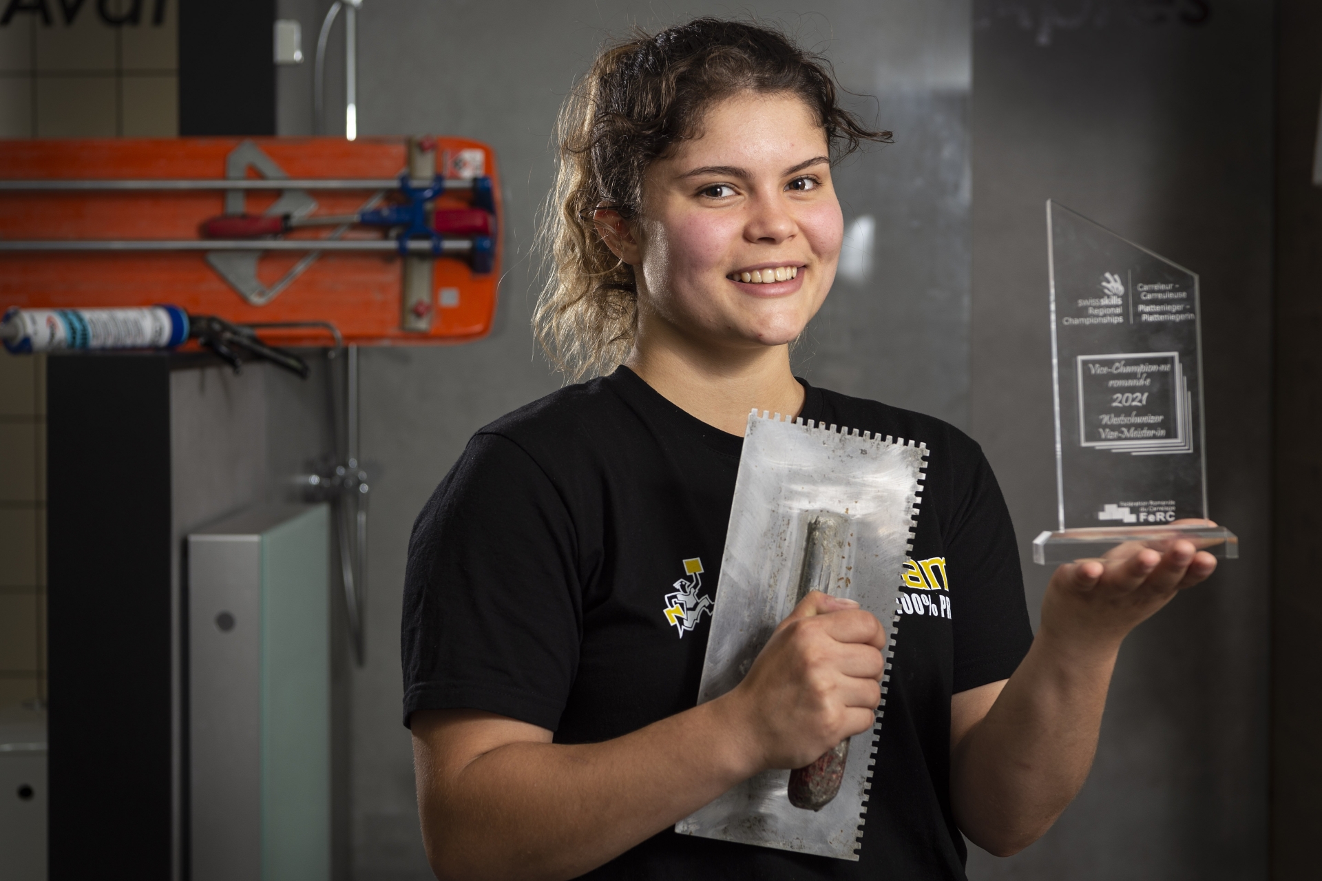 Léa Baeriswyl, ici dans l'entreprise Proceram à Sion qui l'emploie, ne cache pas sa joie en portant son trophée.