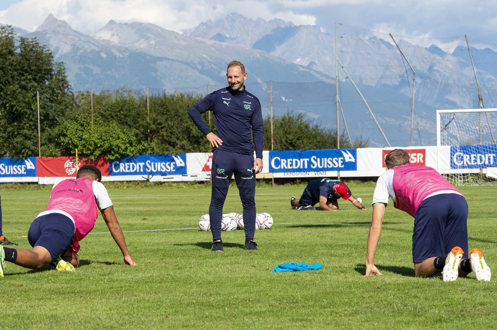 Mauro Lustrinelli supervise avec le sourire les exercices d'étirement des joueurs de l'équipe de Suisse des moins de 21 ans sur le terrain du Christ-Roi à Lens.