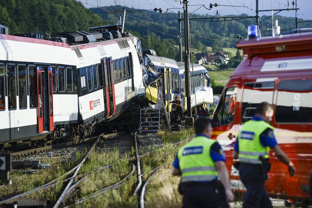 Des policiers et des pompiers travaillent sur le lieu de l'accident entre deux trains ce lundi 29 juillet 2013 a Granges-pres-Marnand dans le canton de Vaud. Une collision frontale entre deux trains s'est produite lundi en fin de journee sur la ligne Palezieux-Payerne. Plusieurs personnes sont blessees. (KEYSTONE/Laurent Gillieron)