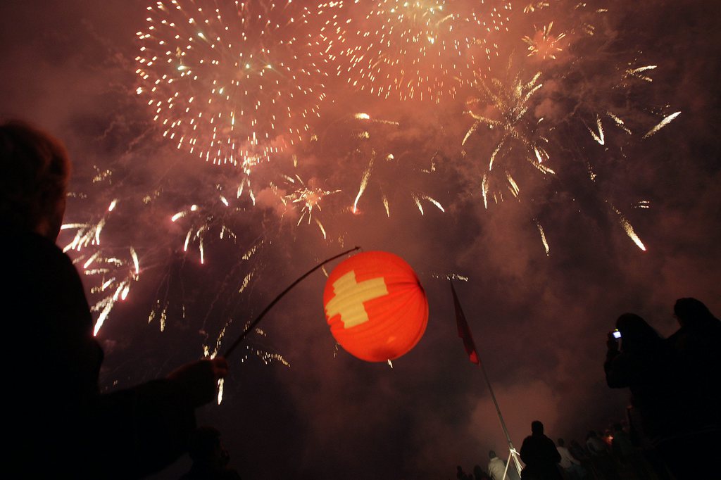 Des personnes regardent le feu d'artifice, lors de la fete nationale, ce vendredi 1 aout 2008 a Anieres pres de Geneve. (KEYSTONE/Salvatore Di Nolfi)