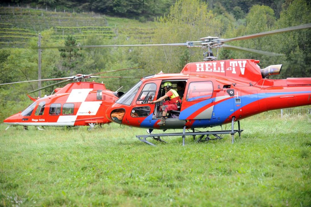 Ein Rega-Helikopter, links, befindet sich in der Naehe einer Helikopter-Absturzstelle, um sich zur Absturzstelle aufzumachen, am Dienstag, 18. September 2012, in Lodano. Heute gegen 16.30 Uhr ist im Maggiatal auf dem Gemeindegebiet von Lodano in einem schwer zugaenglichen Gebiet ein Hubschrauber der Firma Heli-TV abgestuerzt. Der Pilot kam dabei ums Leben. Der Absturz geschah auf 1300 Metern Hoehe. (KEYSTONE/Ti-Press/Samuel Golay)......