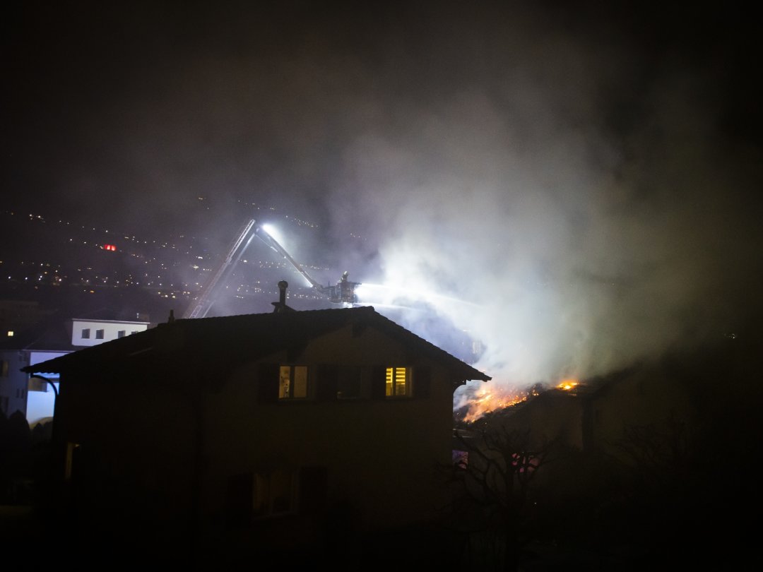 Les pompiers aspergent le toit en feu de la villa.