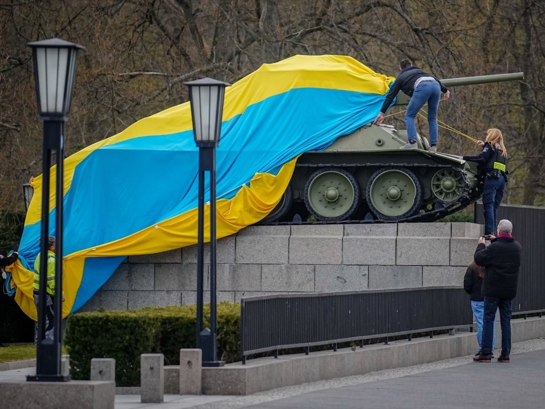 Des policiers retirent le drapeau de l’Ukraine d’un char historique au mémorial des soldats soviétiques tués pendant la Seconde Guerre mondiale  à Berlin.