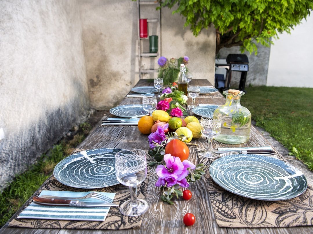 Une table rustique, décorée d'agrumes, de fleurs, de grenades, d'artichauts et de branches d'olivier pour la Sardaigne. Les assiettes ont été gracieusement mises à disposition par Restorex.