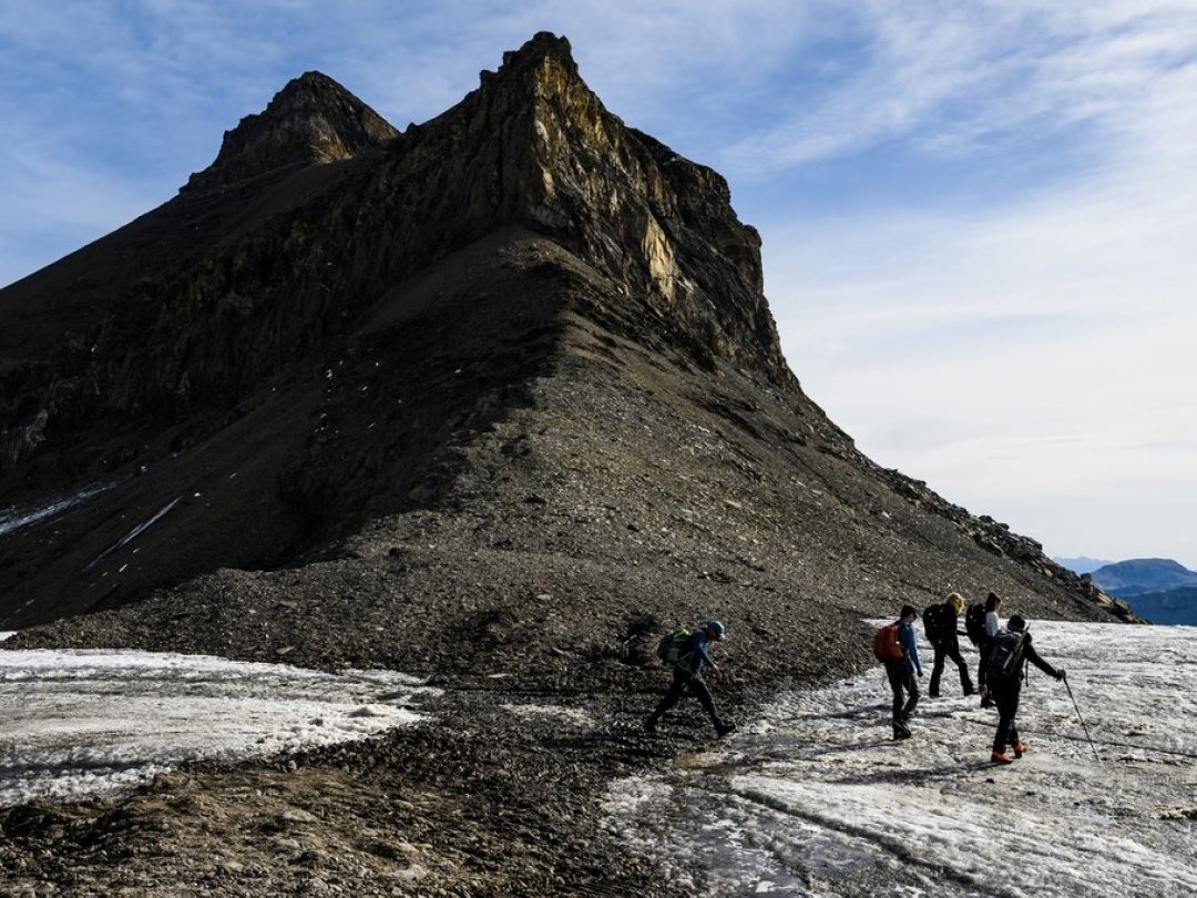 Des randonneurs marchent entre le glacier du Scex Rouge et le glacier de Tsanfleuron, désormais séparés.