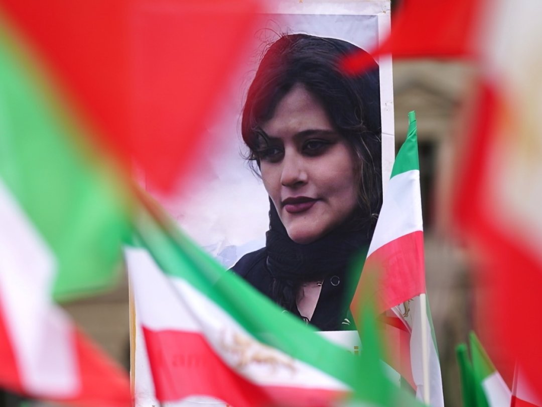 Un portrait de Mahsa Amini et des drapeaux iraniens sont brandis lors d'une manifestation à Berlin, le 1er octobre.