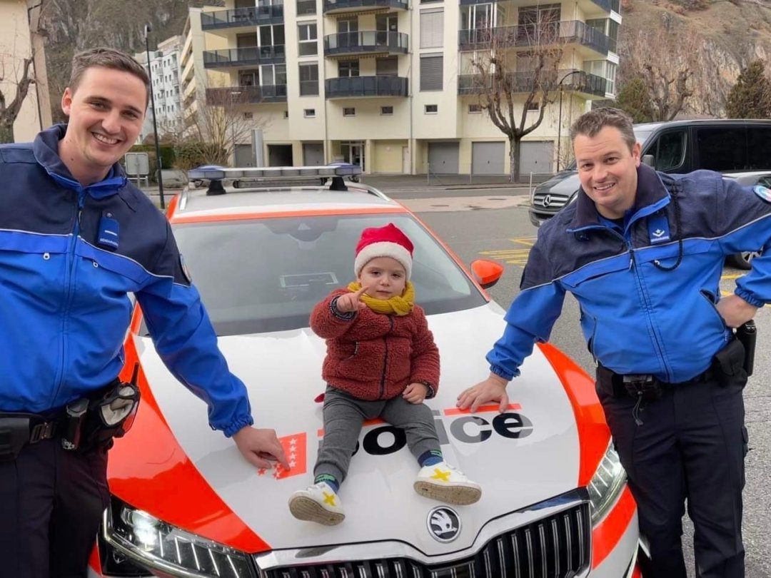 Daniel Imboden et Gaëtan Lathion, de la police valaisanne, posent avec le petit Viktor.