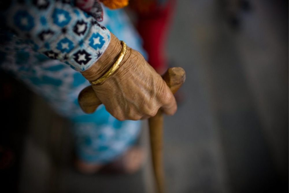 epa03416997 A detail shows the hand of an elderly Nepalese woman as she leaves a celebration function to mark the International Day of Older Persons in Kathmandu, Nepal, 01 October 2012. The Kathmandu Municipality honored 12 elderly women aged over 100. Each woman received NRS 10,000 (USD 117) as a token or gift voucher. All United Nations member states mark the day of older persons every 01 October to raise awareness about issues affecting the elderly.  EPA/NARENDRA SHRESTHA