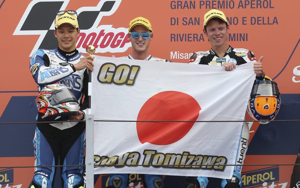 From left, second placed Japan's Takaaki Nakagami, winner Pol Espargar?, of Spain, and  third placed Tito Rabat, also of Spain, hold a flag for late Japanese rider Shoya Tomizawa, who died in a fatal crash on this circuit in 2010, on the podium after the San Marino Moto 2 grand prix at the Misano circuit, in Misano Adriatico, Italy, Sunday, Sept. 15, 2013. (AP Photo/Antonio Calanni)