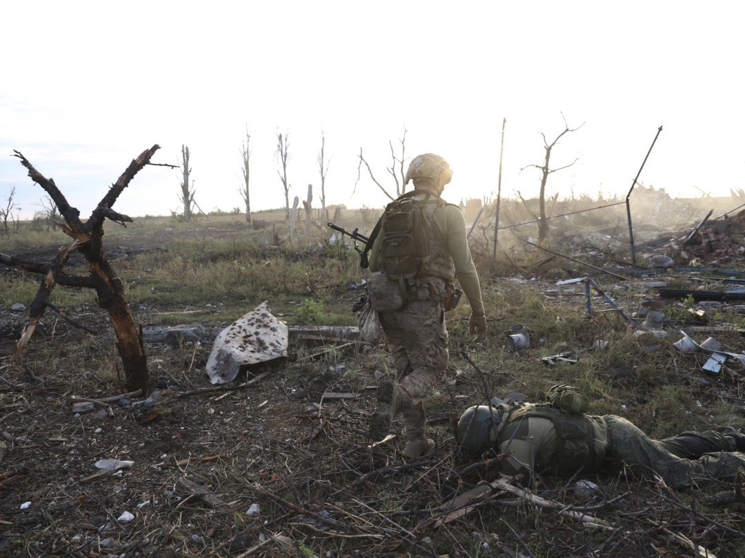 Un commandant de la 3ème brigade d'assaut ukrainienne "Azov" et la dépouille d'un soldat russe sur le front à Andriivka, dans le Donetsk, le 16 septembre.