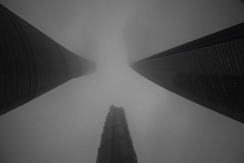 The Shanghai Tower under construction, left, is seen with other skyscrapers, Jinmao Tower, center, and Shanghai World Financial Center, right, in the haze in Shanghai, China, Monday, Dec. 9, 2013. The dirty air that has gripped Shanghai and its neighboring provinces for days is attributed to coal burning, car exhaust, factory pollution and weather patterns, and is a stark reminder that pollution is a serious challenge in China. (AP Photo/Eugene Hoshiko)