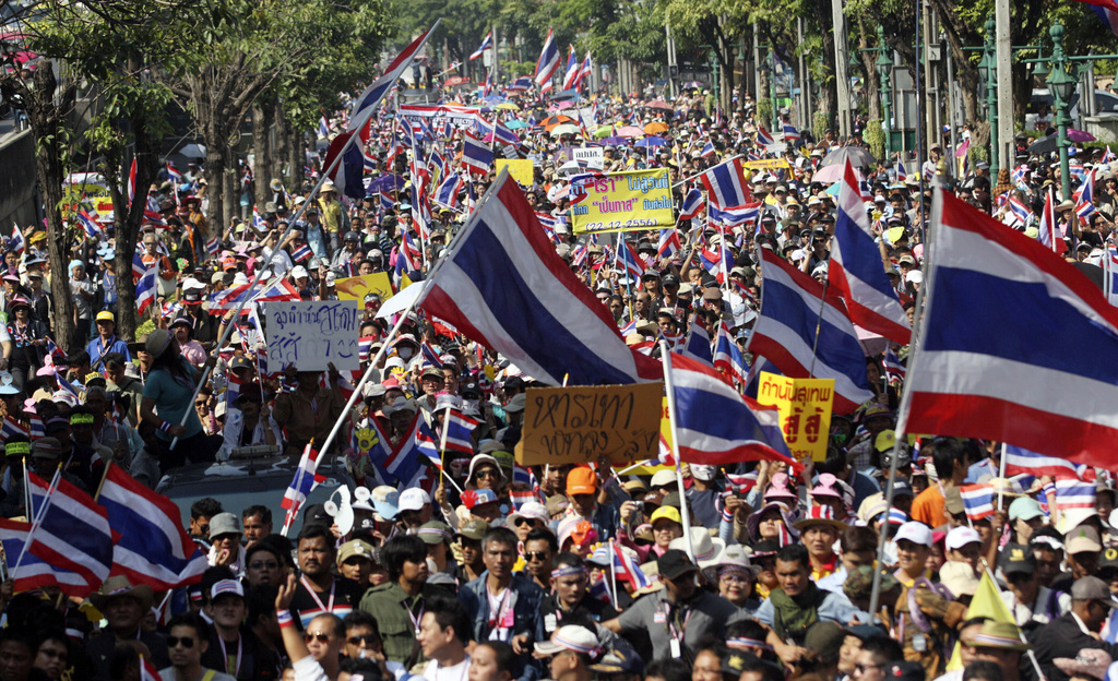 Thai anti-government protesters march in a street, Sunday, Dec. 22, 2013, in Bangkok, Thailand. Thailand's main opposition Democrat Party said it would boycott February's general election, deepening a political crisis as protesters called for another major rally Sunday to step up efforts to oust the government and force political reforms. (AP Photo/Sakchai Lalit)