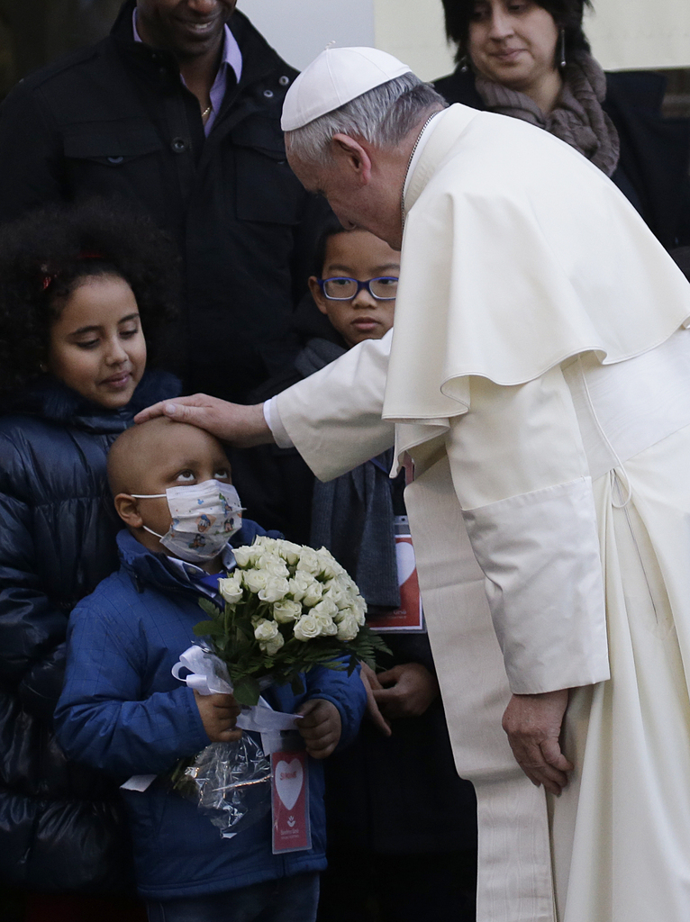Pope Francis caresses a child as he arrives at the "Bambin Gesu'" children's hospital in Rome, Saturday, Dec. 21, 2013. (AP Photo/Gregorio Borgia)...