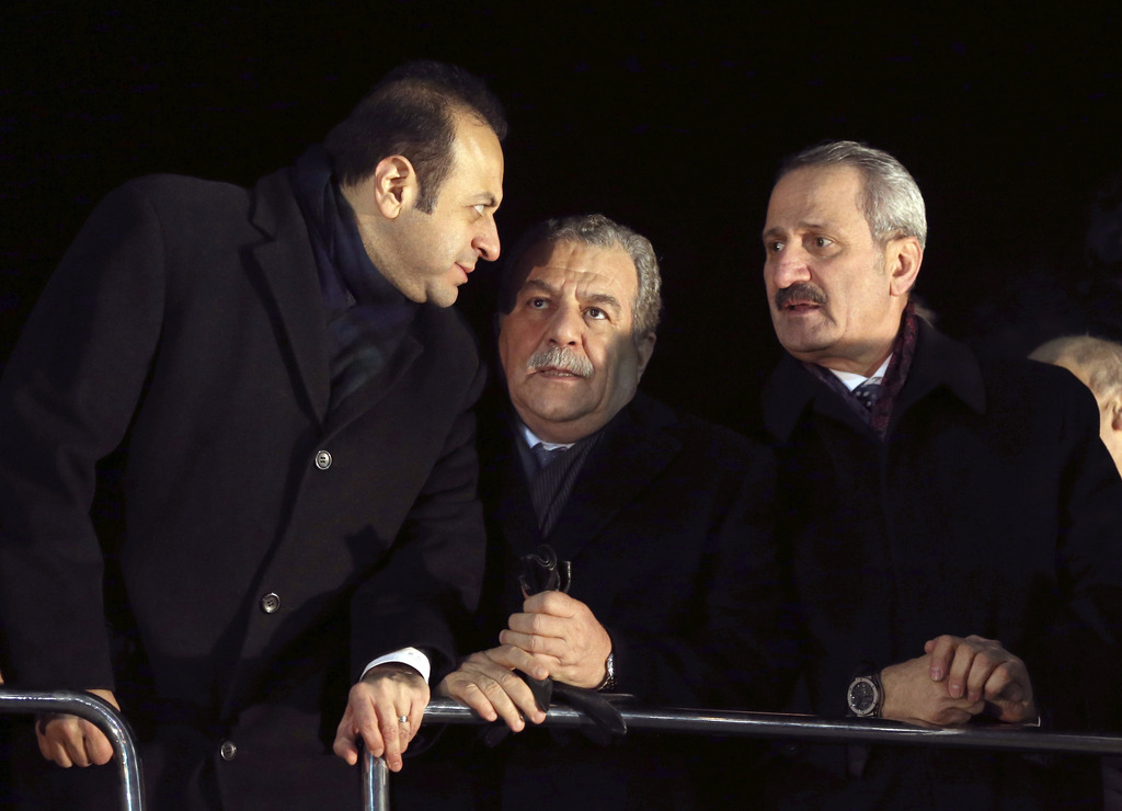 In this photo taken late Tuesday, Dec. 24, 2013, Turkey's Economy Minister Zafer Caglayan, right, Interior Minister Muammer Guler, center, and EU Affairs Minister Egemen Bagis speak at the Esenboga Airport in Ankara, Turkey. Guler and Caglayan resigned from their posts on Wednesday, Dec. 25, 2013, days after their sons were arrested in a massive corruption and bribery scandal that has targeted Prime Minister Recep Tayyip Erdogan?s allies and has become the worst crisis in his decade in power. Caglayan and Guler both stepped down on Wednesday, despite denying any wrongdoing. (AP Photo)