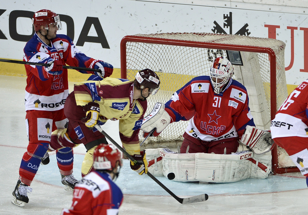 Moscow's Stanislav Egorshev, left, and goalkeeper rastislav Stana, right, vie for the puck with Geneve's Alexandre Picard during the final game between CSKA Moscow and Geneve-Servette at the 87th Spengler Cup ice hockey tournament, in Davos, Switzerland, Tuesday, December 31, 2013. (KEYSTONE/Peter Schneider)