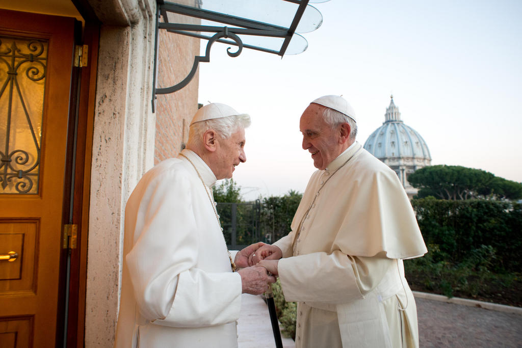 In this picture provided by the Vatican newspaper L'Osservatore Romano, Pope Emeritus Benedict XVI, left, welcomes Pope Francis as they exchanged Christmas greetings, at the Vatican, Monday, Dec. 23, 2013. (AP Photo/L'Osservatore Romano, ho)