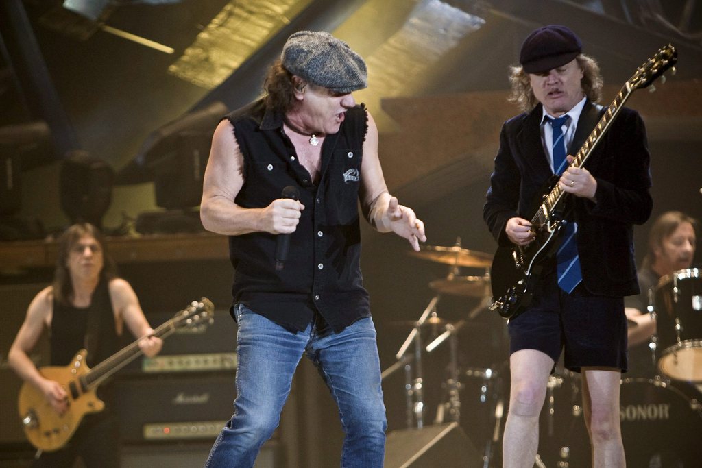 Le chanteur Brian Johnson, avec, à l'arrière Malcom Young et son frère Angus, éternel écolier...