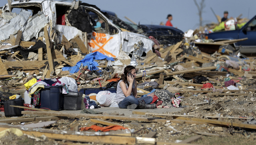 Destiny Simmons sits in the rubble of her home that was destroyed by a tornado as she talks on a cell phone, Monday, April 28, 2014, in Vilonia, Ark. (AP Photo/Eric Gay)