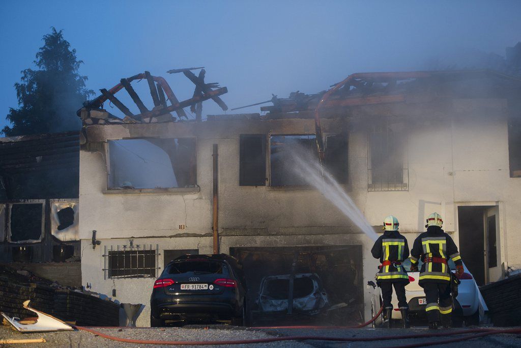 Des pompiers travaillent apres l'explosion d'une villa de la Clamogne ce lundi 7 janvier 2013 a Marsens dans le canton de Fribourg. Quatre personnes sont touchees. Trois sont a l'hopital et une personne n'a pas encore ete trouvee. (KEYSTONE/Jean-Christophe Bott)