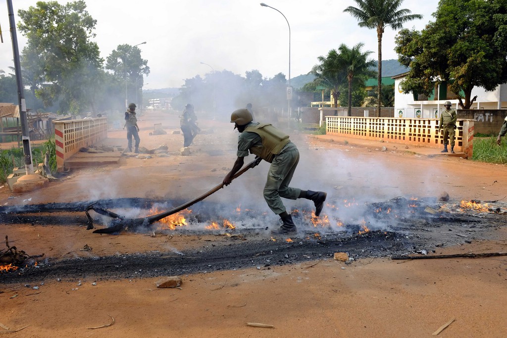 African Union MISCA forces from Cameroon clear a barricade set by protesters,  Thursday, May 29, 2014 in Bangui, Central African Republic. Thousands took to the streets following Wednesday's attack by Muslim militias on a Christian church that left at least five dead and scores wounded. (AP Photo/Jerome Delay)