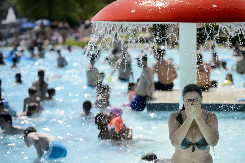People jump in the water and enjoy the sunny and warm weather in a public bath in Morges, western Switzerland, Monday, June 9, 2014. (KEYSTONE/Laurent Gillieron)
