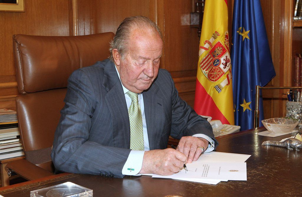 A handout document released by Spanish Royal Household on 02 June 2014 shows Spain's King Juan Carlos I signing the document of his abdication before he hands it to Spanish Prime Minister Mariano Rajoy (not pictured), at La Zarzuela Palace, in Madrid, Spain, 02 June 2014. Spanish Prime Minister, Mariano Rajoy announced in a press conference on 02 June 2014 that King Juan Carlos I has decided to abdicate in favor of his son Crown Prince Felipe de Borbon.  EPA/SPANISH ROYAL HOUSEHOLD  HANDOUT EDITORIAL USE ONLY/NO SALES