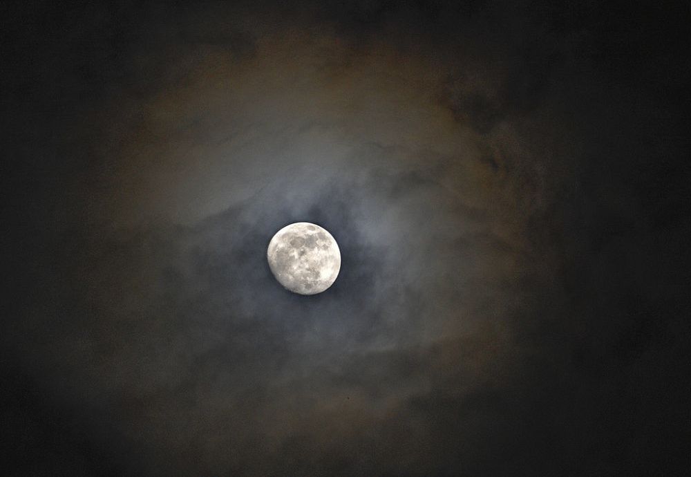 In this Thursday, May 3, 2012, photo, the moon peaks through the clouds in the night sky in Huntsville, Ala. On Saturday, May 5, 2012, the moon will be a "supermoon" or perigee moon as the moon will be at it's closest approach to the earth. It will appear 14 percent larger and 30 percent brighter than normal.  (AP Photo/The Huntsville Times, Bob Gathany)