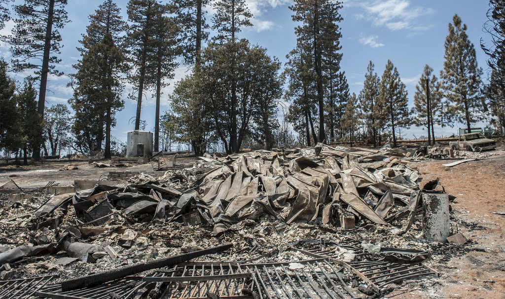 The remains of a burned home lie in the Foresta community in Yosemite National Park in California on Tuesday, July 29, 2014. Fire crews gained ground Tuesday on two of the largest wildfires in California, lifting evacuation orders for about half the homes in the path of a blaze in Yosemite and redeploying firefighters battling another fire in the Sierra Nevada foothills east of Sacramento. (AP Photo/Al Golub)