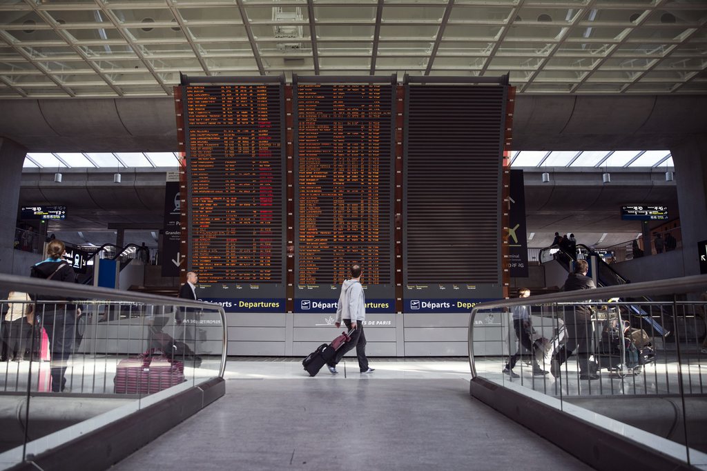 epaselect epa04401550 Passengers pass by in front of a flight information board at Charles de Gaulle Airport in Paris, France, 15 September 2014. French carrier Air France said it had cancelled nearly half its scheduled flights 15 September as pilots began a week-long strike. Major disruptions are expected for the duration of the strike, which is expected to run from 15 to 22 September.  EPA/ETIENNE LAURENT