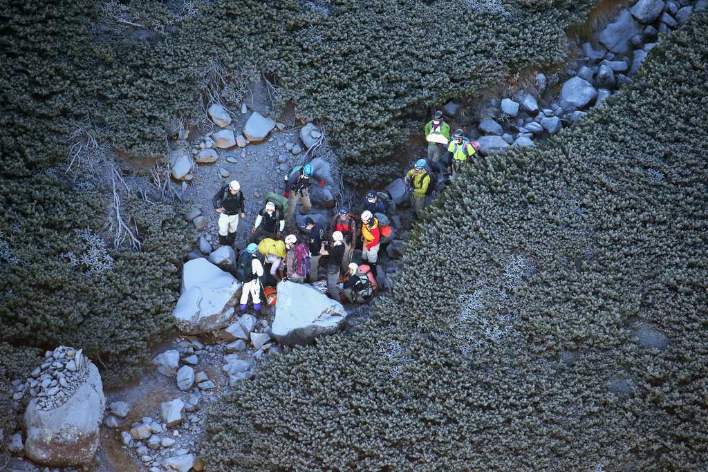 Climbers descend Mount Ontake in central Japan Sunday morning, Sept. 28, 2014, a day after an eruption. Mount Ontake erupted shortly before noon Saturday, spewing large white plumes of gas and ash high into the sky and blanketing the surrounding area in ash. Rescue workers have found 30 or more people unconscious and believed to be dead near the peak of an erupting volcano in central Japan, local government and police said Sunday. (AP Photo/Kyodo News) JAPAN OUT, MANDATORY CREDIT