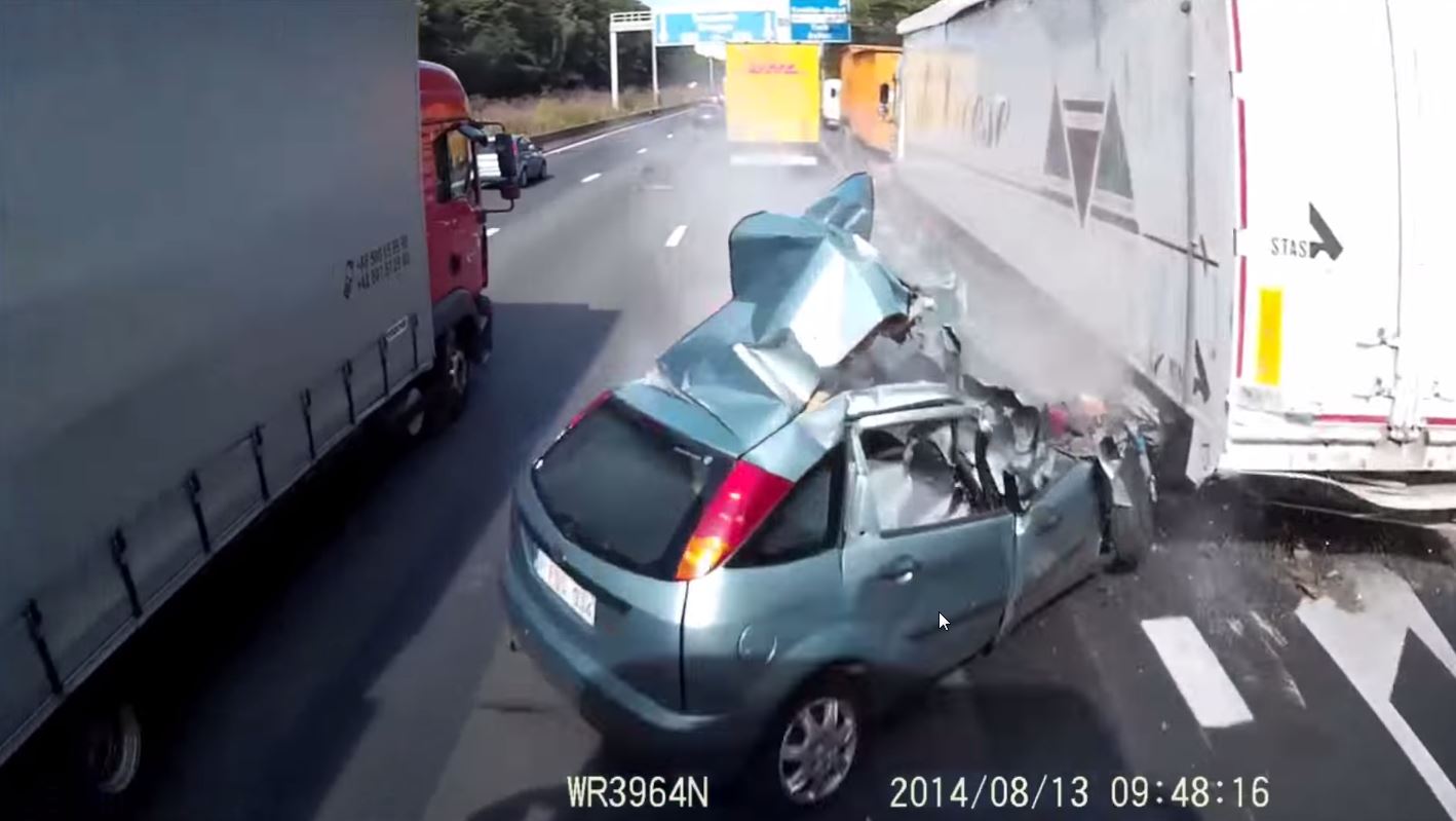 La conductrice a percuté le camion de droite avant d'être shootée par celui qui filme la scène.