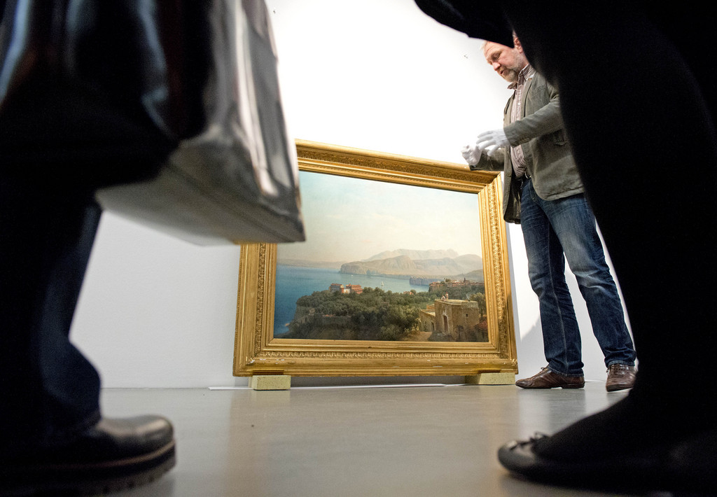 People stand around the painting 'A Valley near Sorrento' (1874) of Louis Gurlitt during a press preview at the exhibition 'Everything strives towards landscape... Landscape paintings of the 19th century in the collection' at the Museum of the Fine Arts (Museum der bildenden Kuenste) in Leipzig, Germany, Friday, March 7, 2014. Visitors can expect to see master works of Caspar David Friedrich, Carl Gustav Carus, Johann Christian Reinhart and others. The exhibition starts on March 8 2014 and lasts until June 22, 2014. (AP Photo/Jens Meyer)