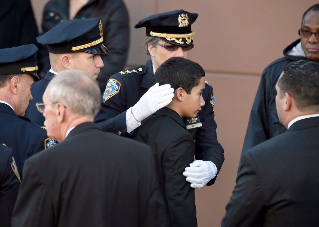 Justin Ramos (au centre), le fils de l'agent de police new yorkais Rafael Ramos, lors de son arrivée aux obsèques de son père. 