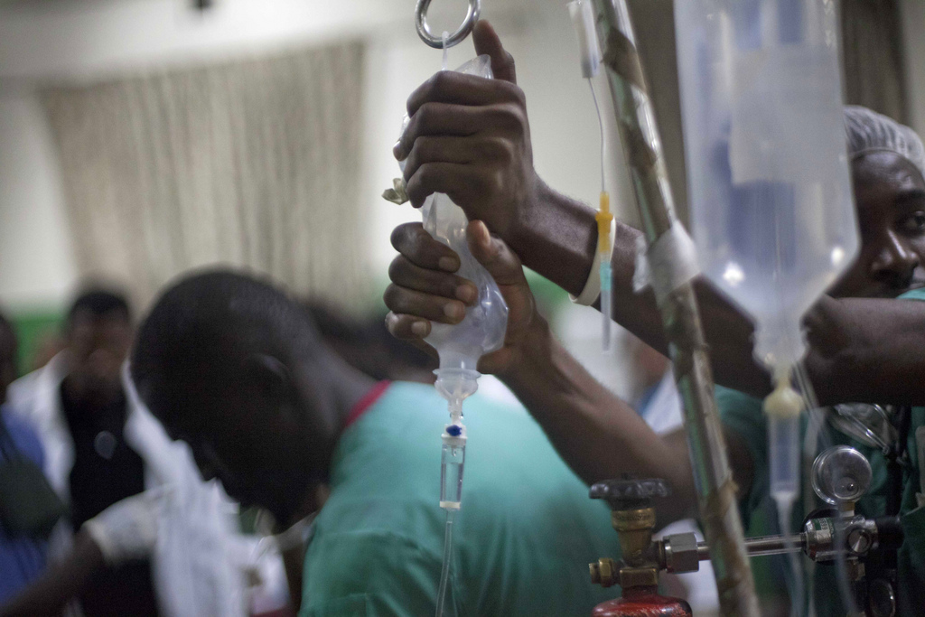 Doctors treat injured people at the emergency room of the General Hospital in Port-au-Prince, Haiti, early Tuesday, Feb. 17, 2015. At least 20 people on a music group's packed Carnival float in the Haitian capital were killed Tuesday when they were electrocuted by a power line, officials said. The accident occurred as thousands of people filled the streets of downtown Port-au-Prince for the raucous annual celebration. People at the scene said someone on the float used a pole or stick to move a power line so the float could pass under it.( AP Photo/Dieu Nalio Chery)