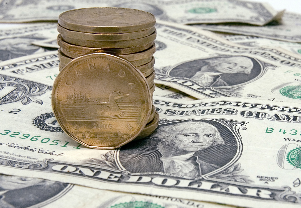 A stack of Canadian dollars, also called loonies, and U.S. dollar bills are seen on Thursday, Sept. 20, 2007 in Montreal, Que. The Canadian dollar moved decisively above 99 U.S. cents, flirting with one-to-one parity with the American dollar for the first time since November 1976.   (AP Photo/Ryan Remiorz, The Canadian Press)