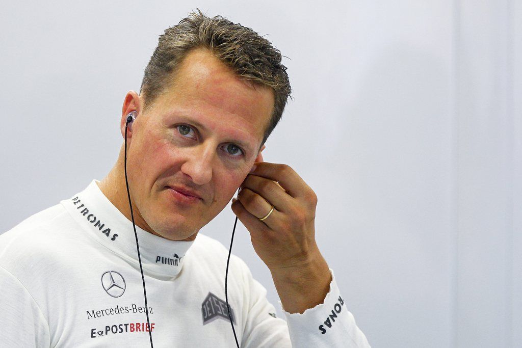 epa04538648 (FILE) A file picture dated 21 September 2012 shows German Formula One driver Michael Schumacher adjusting his earpiece before the first practice session at the Marina Bay Street Circuit in Singapore. One year after his skiing accident at a French Alps resort on 29 December 2013, former seven-times Formula One champion Schumacher is still recovering from a head injury sustained in the accident.  EPA/DIEGO AZUBEL *** Local Caption *** 51560973