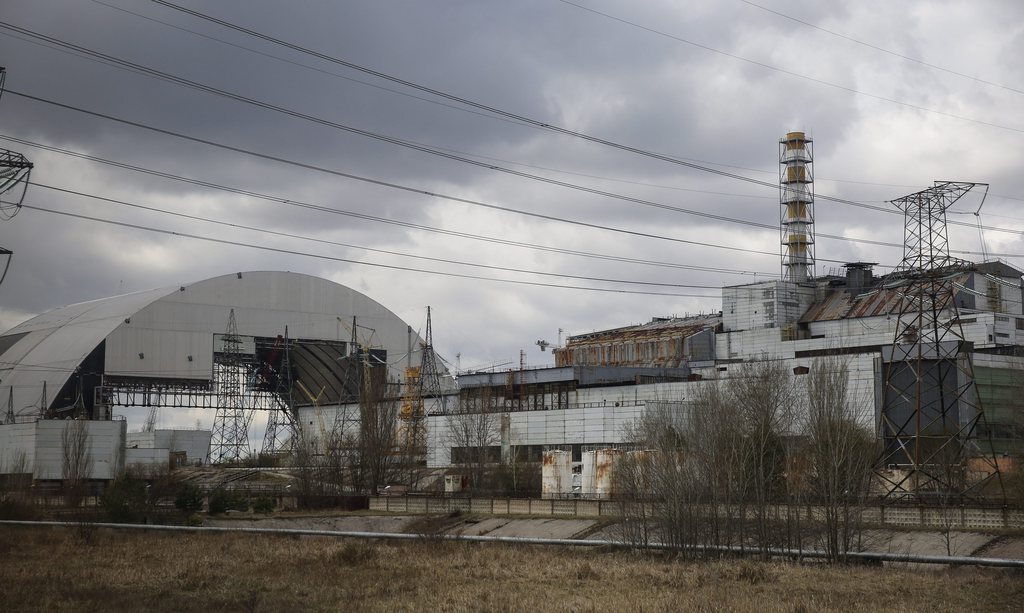 epa04714787 A picture taken through the windows of a van shows a general view of the construction of a new protective shelter which will be mounted over the remains of the Chernobyl nuclear power plant in Ukraine, 21 April 2015. Construction works for a new protective shelter are currently underway at the site of the biggest accident in the history of nuclear power generation.  EPA/ROMAN PILIPEY